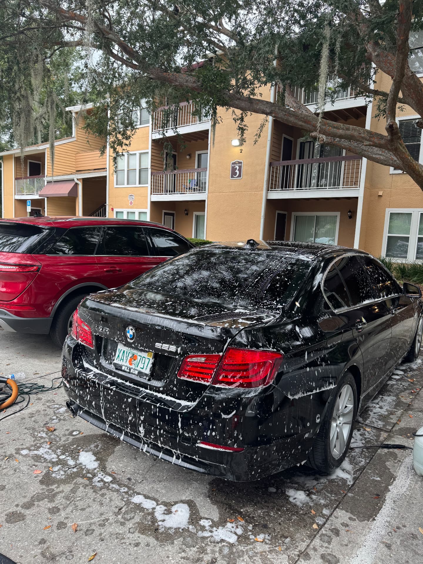 BMW 5 Series covered in foam during a mobile wash